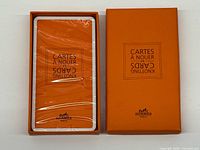 Open Hermès box showing sealed stack of knotting cards