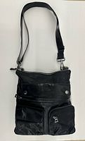 Front view showing zip-top messenger bag, front pockets, strap