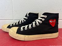 Left and right side view of both sneakers showing heart logo and overall wear