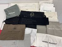 Overview of all dust bags spread on table showing brands and colours