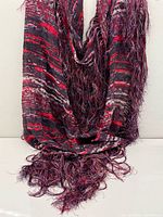 Folded view of scarf with fringe pooled
