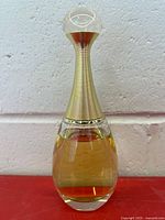Full view of J'adore perfume bottle showing liquid level