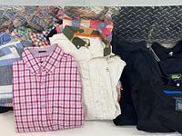Assorted folded shirts, fleece and jacket displayed on table