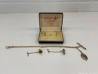Full lot showing watch chain, two tie studs and presentation box interior