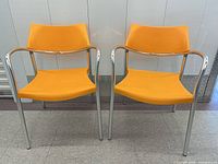 Front view of both orange Amat Splash armchairs