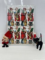 Front view of sheet with die-cut Santas, Santa ornament, black cat ornament