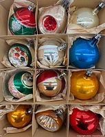 Box showing all twelve glass ornaments in cardboard dividers
