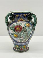Full frontal view of vase showing floral motif and handles