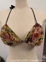 Front view of bikini top on mannequin showing ruffled silk cups and black cord ties