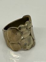 Front view showing Brutalist disc design and gemstones