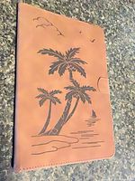 Front of tan folio case with palm tree design