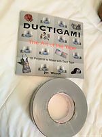 Front cover of Ductigami book and one duct tape roll
