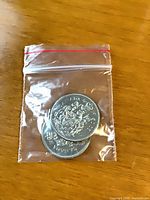 Two Canada 50 cent coins in resealable plastic bag