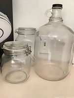 Two clamp-top jars and growler arranged side by side