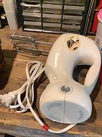 Overall view of Hamilton Beach hand mixer with cord and beater