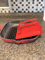 Square red enameled cast iron grill pan with press inside