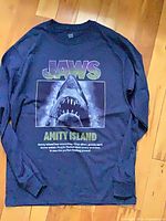 Full view of navy long sleeve Jaws tee laid flat