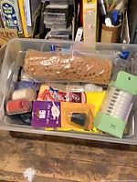 Overall view of bin with sponge, bobbins, cane tip, tape, gloves