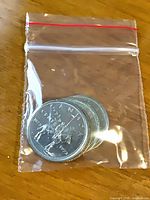 Four 1973 Canadian RCMP quarters in plastic bag
