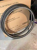 Pair of black bicycle tires leaned against box