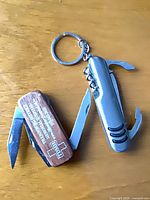 Both pocket multi-tools open showing blades and tools