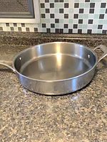 Top view of stainless deep fry pan showing interior and helper handle