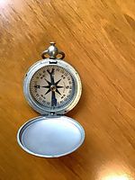 Compass open showing dial, needle, and lid