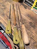 Four rasps/files on workbench showing overall length and handles