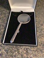 Magnifying glass in open velvet-lined case