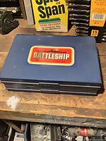 Closed blue plastic Battleship case with logo