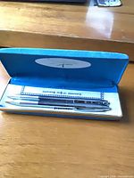 Pen and pencil set inside open blue case