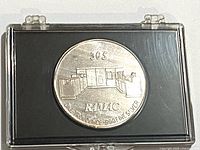 Obverse of silver token in holder showing IBM 305 RAMAC computer design and fineness text