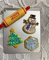 Front of miniature cookie tray ornament showing rolling pin and three cookie shapes