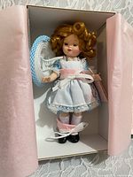 Doll in box with tissue, showing full costume and hat