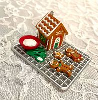 Top view of miniature cookie rack ornament showing gingerbread house, bowl, cookies and 2011 date