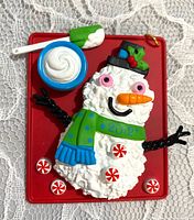 Front view of red cookie-tray ornament with snowman, mug, peppermints, date 2012