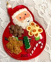 Front of ornament showing Santa face and miniature treats