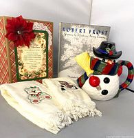 Group shot of scrapbook, book, snowman teapot, two towels