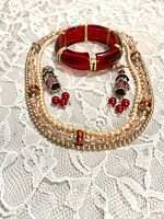 Necklace, bracelet and earrings on lace background