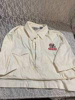Front of polo shirt displaying embroidered 49ers logo and pocket