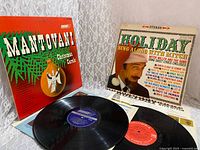 Both album covers displayed with corresponding vinyl discs and lyric sheets