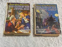 Front view of both Nancy Drew books with dust jackets showing titles and wear