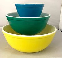Stacked view of blue, green and yellow Pyrex bowls