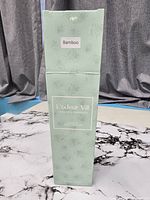 Front of closed mint-green box showing branding and Bamboo scent label
