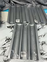 Six-slot view showing two pans stacked, perforated surface and plastic wrap