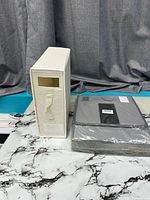 Sealed pack of grey and black organizer beside unsealed sample showing form