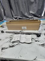 Box, curtain rod sections wrapped, finials, instruction sheet