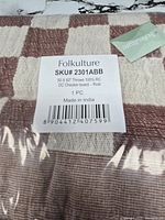 Front view of folded throw blanket in package showing checkerboard pattern and label