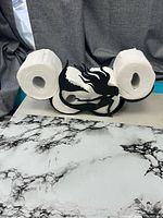 Holder displayed with two rolls to show capacity and shape