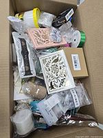 Open box top view showing craft dies, ribbons, sealed items